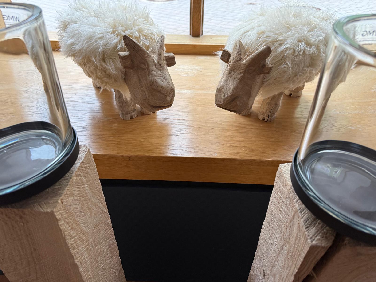 Dekoratives Schaf aus Holz mit Fell auf einer Fensterbank im Laden